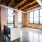 kitchen island surrounded by large, bright windows and open rafters