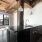 pendant lights hang over kitchen sink/counter which is open to dining area and living room